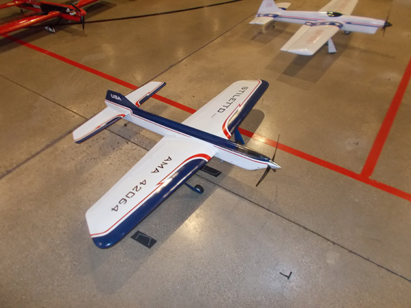 A model airplane on a polished floor with red and blue accents.