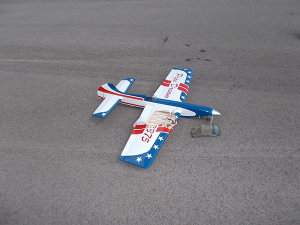 Remote control airplane with patriotic design on pavement.