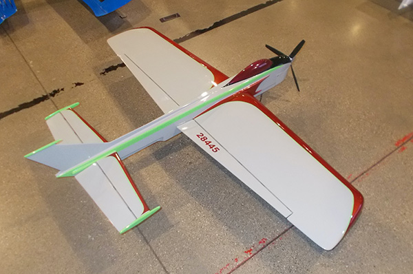 Toy airplane with red and white body, lime green accents, and propeller.