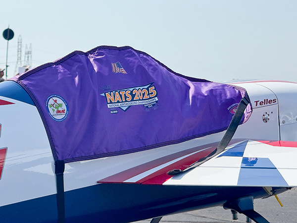 Purple cover on airplane wing with "NATS 2023" logo.