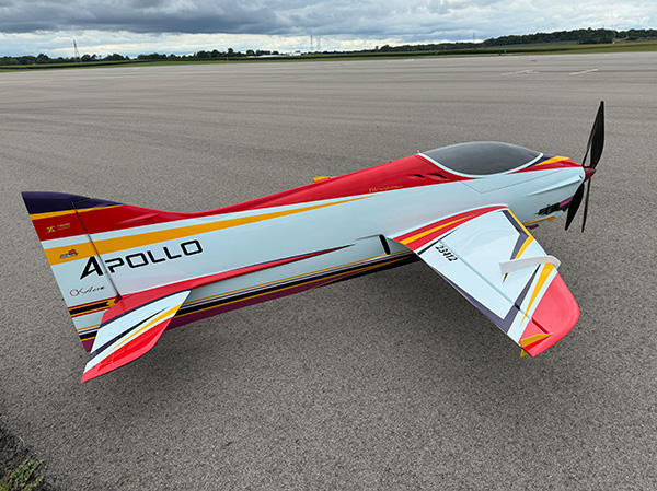 Colorful model airplane on a runway, featuring red, white, and yellow markings.