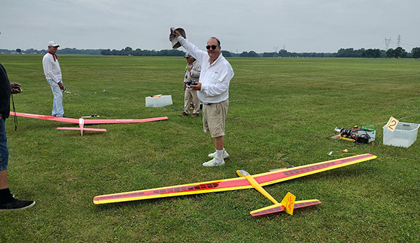 Colorful model airplanes under a canopy on grass.