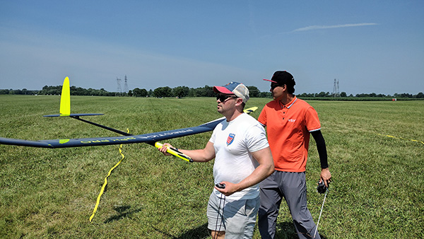 Two men in a field with a large model glider.