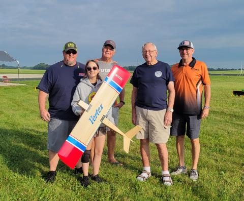 Chuck Bridge donated one of his hand-made, highly-coveted Vortex Quickie 500 pylon racers as a raffle prize to the event. Ray Brown won the Vortex, but gave it to Annabelle Doe. (L to R) Tom Doe, Annabelle Doe holding Vortex, Ray Brown, Chuck Bridge, Randy Bridge. Chuck Bridge donated one of his hand-made, highly-coveted Vortex Quickie 500 pylon racers as a raffle prize to the event. Ray Brown won the Vortex, but gave it to Annabelle Doe. (L to R) Tom Doe, Annabelle Doe holding Vortex, Ray Brown, Chuck Bridge, Randy Bridge.