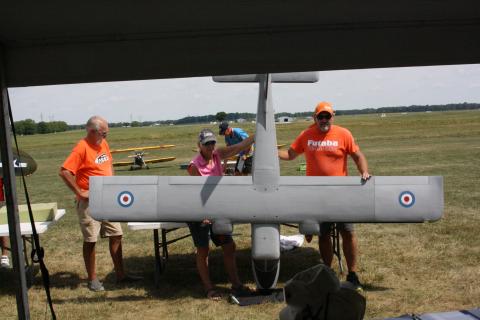 Dale Arvin, Caroll Peck, and Jeremy Arvin hold his entry in Open Scale while judges take in the plan view.