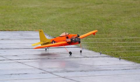 Model plane with orange and yellow wings on a runway.