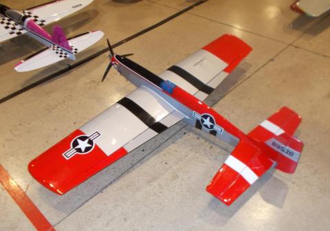 Red and silver model airplane on a concrete floor.