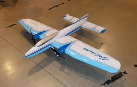 Model airplane with blue and white design on a concrete floor.