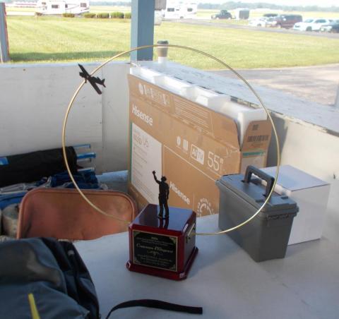 Trophy with a plane figure and a gold circle standing on a table near boxes.