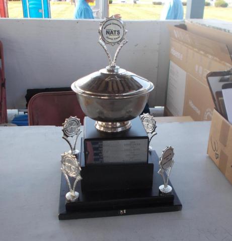 Silver trophy cup on a black base, displayed on a table.