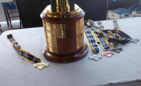 Trophy and medals on a table.