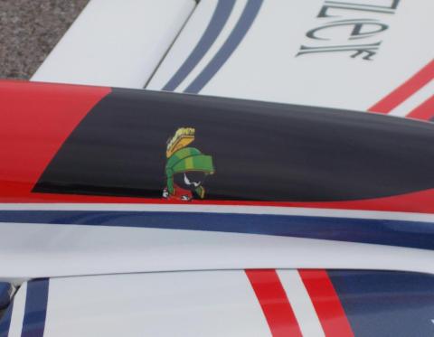 Cartoon character decal on a sleek, red-and-black-striped vehicle surface.