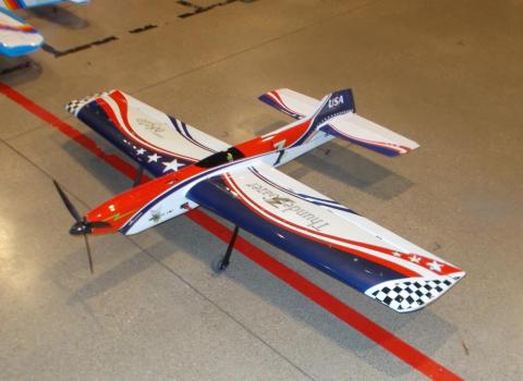 Model airplane with red, white, and blue design on a concrete floor.