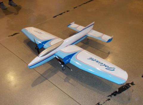 Model airplane with blue and white wings on a glossy floor.