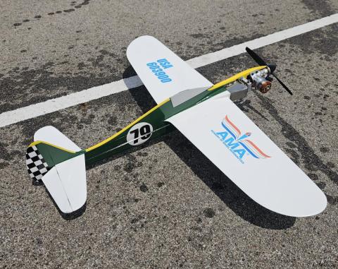 Model airplane on asphalt with a green and white design.