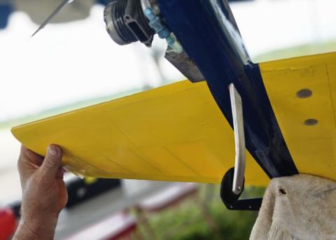 Hands holding a yellow model airplane wing.
