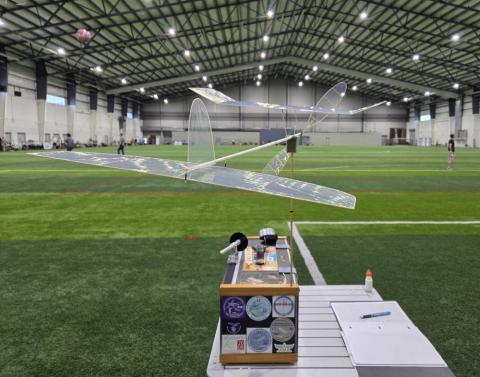 Model airplane on a table in an indoor sports facility.