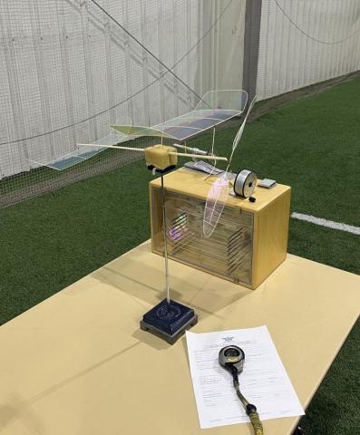 Model airplane displayed on a table in a sports hall.