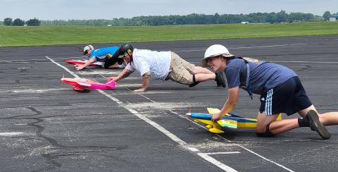 Mitchell Haupt, Annabelle Doe, and Corey Paine push their pilot’s planes at the start of another round.