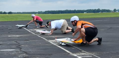 Near to far, Gino Del Ponte, Tom Doe, and Glenn Lang give the “heave ho” to their pilot’s planes for the start.
