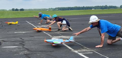 (Near to far) Augie Haupt, Annabelle Doe, and Dan Kane give the push for their pilot’s planes.