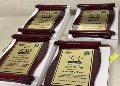 Four wooden award plaques on a table.