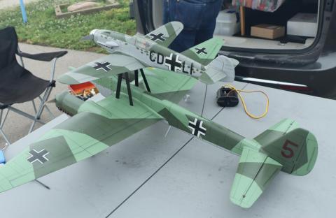Two green World War II model planes on a table, one smaller and mounted on the larger.
