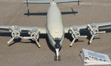 Model propeller plane on a runway with USAF documents nearby.