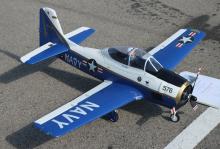 Model Navy airplane with blue and white design on pavement.